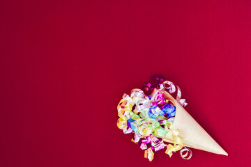 Paper cone with colorful party streamers Viva Magenta background. 