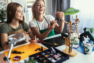 Mother and daughter accessories designers making handmade jewelry in studio workshop. Fashion,...