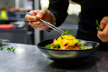 Chef in restaurant kitchen cooking salad