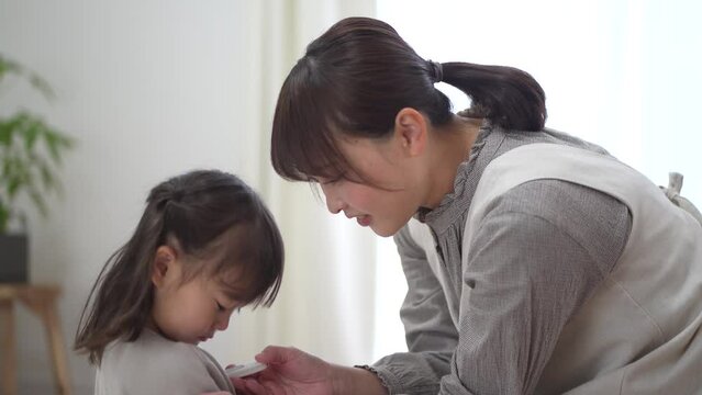 子供の体温を測る母親