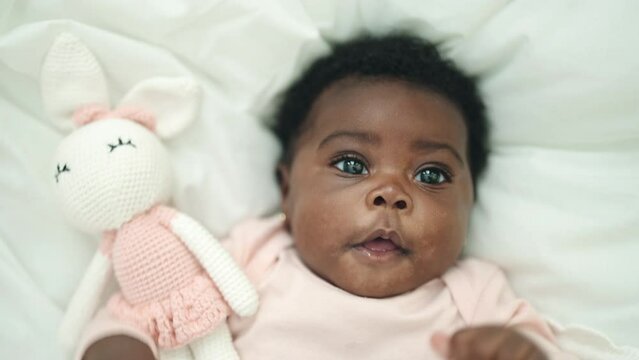 African american baby smiling confident lying on bed at bedroom