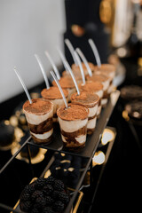 Sweet luxury candy bar on table in restaurant in black tone. Cakes and other sweets