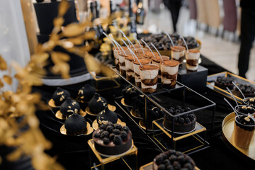 Sweet luxury candy bar on table in restaurant in black tone. Cakes and other sweets