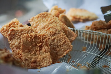 Selective focus, Tempe Goreng or fried tempeh is a type of snack that is popular in Indonesia.