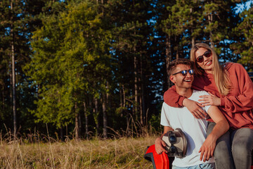 Young happy excited couple enjoying beautiful sunny day while driving a off road buggy car on mountain nature