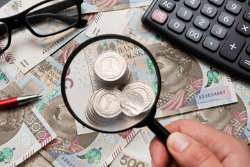 Man using mangifier, polish money concept