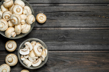 Fototapeta na wymiar Sliced and whole mushrooms in bowl.