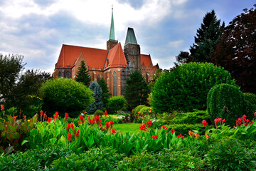 ogród, krzewy i kanny, ceglany budynek w ogrodzie , Canna or canna lily, czerwony paciorecznik, kanna, designer garden © kateej