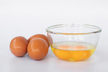 Fresh eggs in a cup and full of eggs on the side