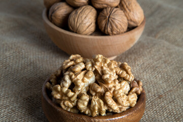 Peeled walnuts and whole walnuts on burlap sack