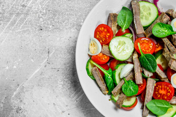 Healthy salad. Salad with boiled beef, vegetables and quail eggs.
