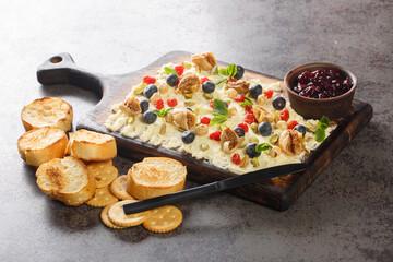 Snack Butter board topped with dried figs and cherry, fresh mint, nuts and blueberries close-up on the table. Horizontal