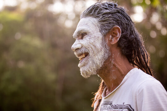 Aboriginal man wearing white face paint smiling