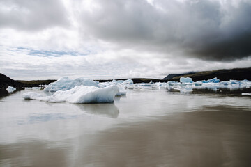 Many icebergs and ice floes in the glacial lagoon Fjallsárlón in iceland, which has broken away from the glacier tongue Fjallsjökull. With a view of Hvannadalshnúkur in the background.