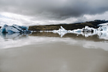 Many icebergs and ice floes in the glacial lagoon Fjalls&aacute;rl&oacute;n in iceland, which has broken away from the glacier tongue Fjallsj&ouml;kull. With a view of Hvannadalshn&uacute;kur in the background.