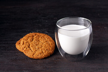 a glass of milk and oatmeal cookies on the table