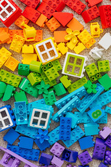 Naklejka premium Top view of various colorful rainbow colored constructor pieces. Bright stackable plastic toy bricks sorting by colors. Educational games for Colors sorting. Developing Montessori toddlers activities.