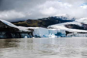 Many icebergs and ice floes in the glacial lagoon Fjalls&aacute;rl&oacute;n in iceland, which has broken away from the glacier tongue Fjallsj&ouml;kull. With a view of Hvannadalshn&uacute;kur in the background.