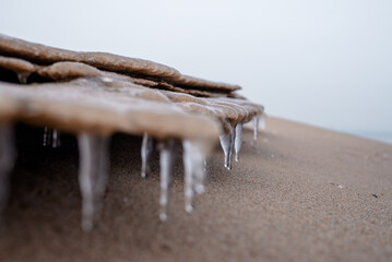 Background texture of icicles and sand. Winter beautiful background. Seasonal landscape details
