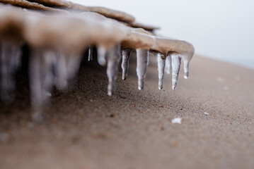 Background texture of icicles and sand. Winter beautiful background. Seasonal landscape details
