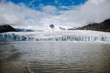 View of the glacier tongue Fjallsjökull with its icebergs and the glacier lagoon Fjallsárlón in Iceland. With a view of Öræfajökull in the background.