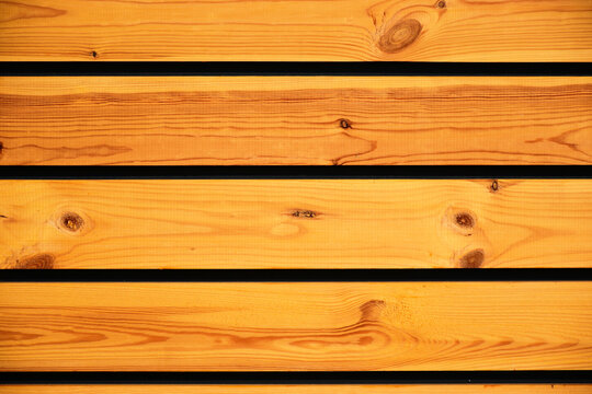pine wood texture background. Stained yellow fence wooden planks. planks with joint, soft wood grain. construction material. wood texture and patter. wooden fence. horizontal boards. closeup view.