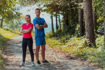 Naklejka na ściany i meble Couple enjoying in a healthy lifestyle while jogging on a country road