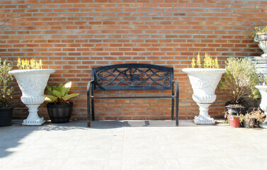 Black steel bench placed in front of the brick wall.