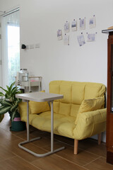 Yellow bench placed in front of the white wall.