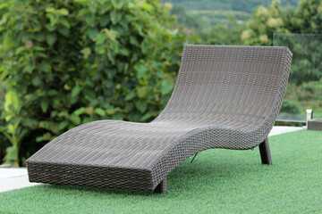 Relaxing rattan chairs on artificial grass floor.