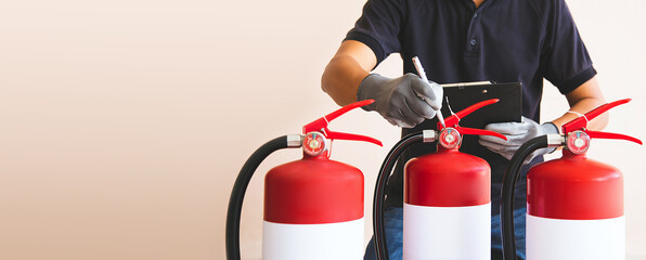 Close up fire extinguisher and firefighter checking pressure gauge level for protection and prevent...