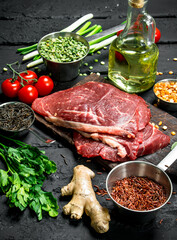 Healthy food. Raw beef steaks with organic vegetables and spices .