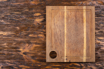 Empty old cutting board on a wooden background. Layout for the recipe.