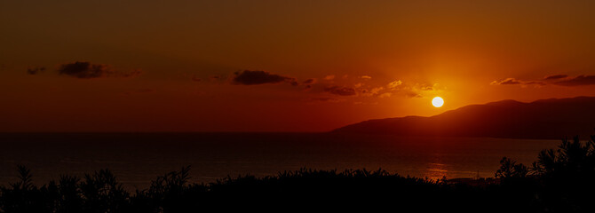 Sunset and Sunrises with silhouettes of lanterns rooftops and golden light over the sea