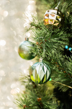 Vertical image of Christmas baubles on tree with bokeh copy space