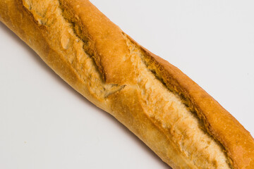 French baguette on a white background with copy space. Delicious appetizing crust of a bun close-up
