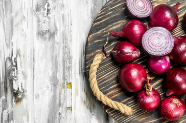 Fototapeta na wymiar Whole and cut red onions on tray.