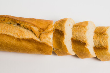 Appetizing French bun crust close-up. Sliced french baguette on a white background with space for text