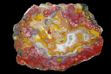 A cross section of the agate stone with quartz geode. Multicolored silica bands colored with metal oxides are visible. Macro photography of the surface of the cut. Origin: Atlas mountains, Morocco.