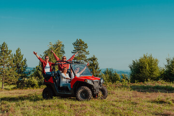 Group young happy people enjoying beautiful sunny day while driving a off road buggy car on mountain nature