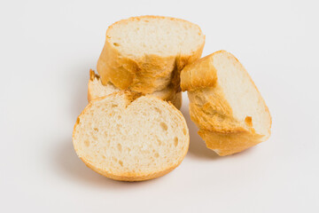 Pieces of French bread, baguette with an appetizing crust, on a white background, macro.