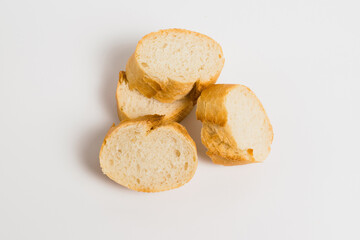 Pieces of French bread, baguette with an appetizing crust, on a white background, macro.