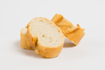 Pieces of French bread, baguette with an appetizing crust, on a white background, macro.