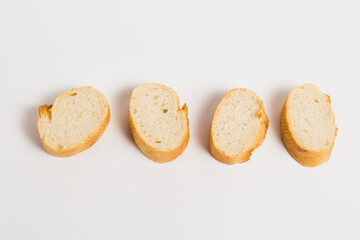 Pieces of French bread, baguette with an appetizing crust, on a white background, macro. Concept of healthy eating.