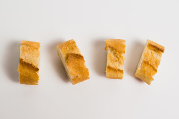 Pieces of French bread, baguette with an appetizing crust, on a white background, macro. Concept of healthy eating.