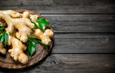 Ginger with leaves on the cutting Board.