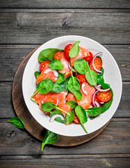 Fish salad. Salad with slices of salmon, tomatoes and spinach with lime juice.
