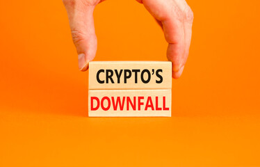 Crypto downfall symbol. Concept words Cryptos downfall on wooden blocks. Beautiful orange table orange background. Businessman hand. Business and crypto downfall concept. Copy space.