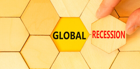 Global recession symbol. Concept words Global recession on wooden puzzles. Beautiful yellow table yellow background. Businessman hand. Business and global recession concept. Copy space.