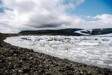 View of the glacier tongue Fjallsjökull with its icebergs and the glacier lagoon Fjallsárlón in Iceland. With a view of Öræfajökull in the background.